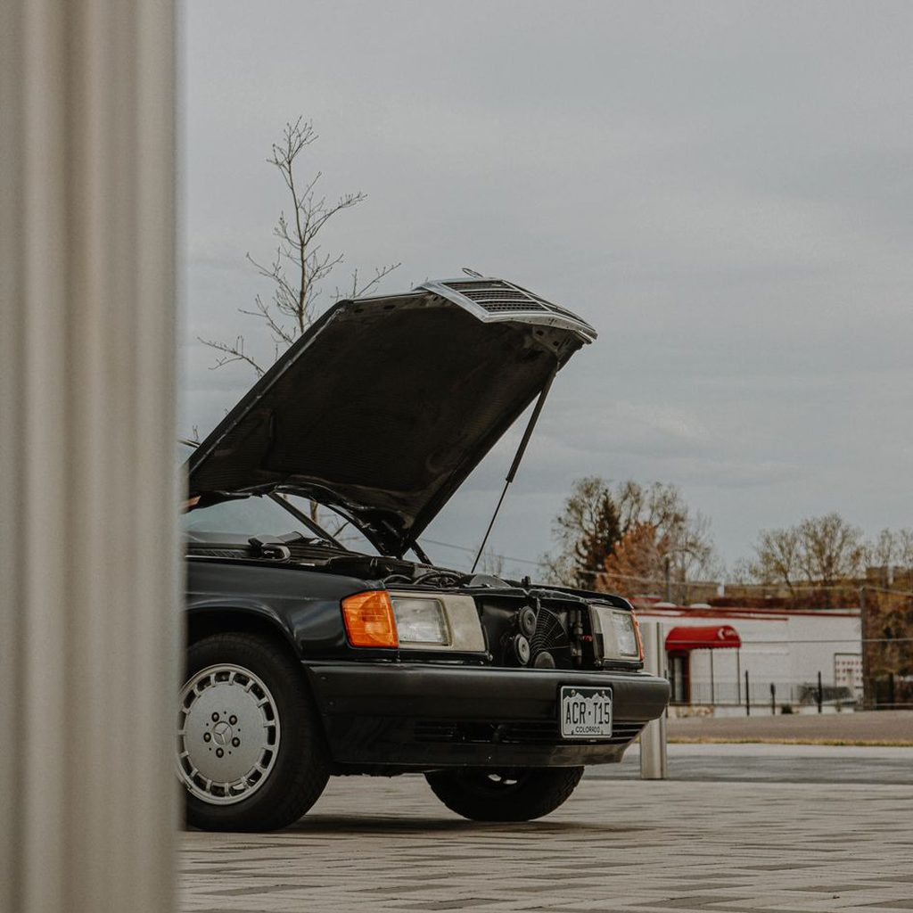 Experienced automotive repair team in modern luxury service center with detailed technical focus